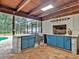 Outdoor kitchen with cabinets, sink and fireplace at 25555 Oaks Blvd, Land O Lakes, FL 34639