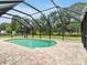 Inviting pool area surrounded by a screened enclosure and lush trees at 25555 Oaks Blvd, Land O Lakes, FL 34639