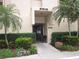 Inviting condo entrance with lush landscaping and seating at 2616 Cove Cay Dr # 104, Clearwater, FL 33760