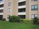 Exterior view of condo building with lush landscaping and bright green lawn at 2616 Cove Cay Dr # 104, Clearwater, FL 33760