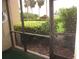 View from the screened lanai features manicured landscaping and tropical palm trees at 2616 Cove Cay Dr # 104, Clearwater, FL 33760