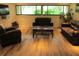 Cozy living room with hardwood floors, comfortable seating, and natural light from large windows at 2616 Cove Cay Dr # 104, Clearwater, FL 33760