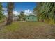 Spacious backyard featuring a green home with a covered patio and mature trees at 2931 23Rd N St, St Petersburg, FL 33713