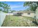 Backyard with a white fence and a view of the house with screened porch at 3021 Jarvis St, Holiday, FL 34690