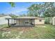 Backyard with a white fence and a view of the house with screened porch at 3021 Jarvis St, Holiday, FL 34690