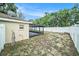 Backyard with a white fence and a view of the house with screened porch at 3021 Jarvis St, Holiday, FL 34690
