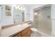 Bathroom featuring a glass-enclosed shower, modern vanity, decorative mirror, and updated fixtures at 3021 Jarvis St, Holiday, FL 34690