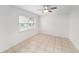 Bright bedroom featuring neutral tile flooring, a ceiling fan and a large window at 3021 Jarvis St, Holiday, FL 34690