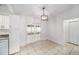 Bright dining area with white cabinets, sliding doors to the outside, and a modern pendant light at 3021 Jarvis St, Holiday, FL 34690