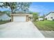 Charming single-story home with a two-car garage, stone accents, and a concrete driveway at 3021 Jarvis St, Holiday, FL 34690