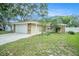 Charming single-story home with a two-car garage, stone accents, and well-maintained lawn at 3021 Jarvis St, Holiday, FL 34690