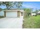 Charming single-story home with a two-car garage, stone accents, and well-maintained lawn at 3021 Jarvis St, Holiday, FL 34690
