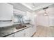 Charming kitchen with granite countertops, stainless steel sink, and sleek white cabinets at 3021 Jarvis St, Holiday, FL 34690