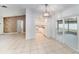 Open-concept living space with tile floors, white cabinets, and sliding glass doors at 3021 Jarvis St, Holiday, FL 34690