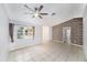 Bright living room features a ceiling fan, tile flooring, and large windows for ample natural light at 3021 Jarvis St, Holiday, FL 34690