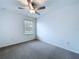 This bedroom features a ceiling fan, a window, and neutral-colored carpet at 30729 Veridian Way, Wesley Chapel, FL 33543