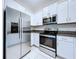 Bright kitchen with stainless steel appliances and white cabinets offers sleek design at 30729 Veridian Way, Wesley Chapel, FL 33543