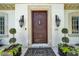 A beautiful decorative wood front door framed by sconces and manicured topiaries enhance the entrance at 3144 W Waverly Park, Tampa, FL 33629