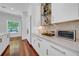 Bright kitchen featuring white cabinetry, marble countertops, and modern appliances, with stylish shelving at 3144 W Waverly Park, Tampa, FL 33629