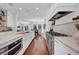 Open-concept kitchen with white cabinetry, stainless steel appliances, and a view into the dining area at 3144 W Waverly Park, Tampa, FL 33629