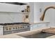 Close up of a gourmet range with white cabinets, custom shelving, and marble countertops in the kitchen at 3144 W Waverly Park, Tampa, FL 33629