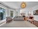 Bright living room features hardwood floors, plentiful windows with modern draperies, and designer lighting at 3144 W Waverly Park, Tampa, FL 33629