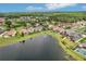Picturesque aerial view of a waterfront community featuring well-maintained homes, mature trees, and a serene lake at 3228 Stonegate Falls Dr, Land O Lakes, FL 34638