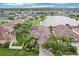 Aerial view of the home showcases its great location on a lake and well-maintained landscaping at 3228 Stonegate Falls Dr, Land O Lakes, FL 34638