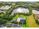 Aerial view of a lakefront community with a pool and amenities center at 3228 Stonegate Falls Dr, Land O Lakes, FL 34638