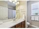 Clean bathroom with white vanity, neutral walls, decorative mirror and natural light from a window at 3228 Stonegate Falls Dr, Land O Lakes, FL 34638