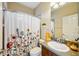 Bathroom with a floral curtain, decorative mirror, and a single sink vanity at 3228 Stonegate Falls Dr, Land O Lakes, FL 34638