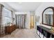 Cozy bedroom with neutral carpet, bright natural light, decorative curtains, a dresser and a decorative mirror at 3228 Stonegate Falls Dr, Land O Lakes, FL 34638