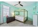 Charming bedroom with a four-poster bed, neutral carpet, bright windows, and soft pastel decor at 3228 Stonegate Falls Dr, Land O Lakes, FL 34638