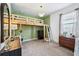 Unique bedroom with wooden loft bed, green accent wall, neutral carpet, decorative lighting and a desk area at 3228 Stonegate Falls Dr, Land O Lakes, FL 34638
