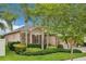 A beautifully landscaped home with stone accents and mature trees at 3228 Stonegate Falls Dr, Land O Lakes, FL 34638