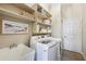 Practical laundry room with modern washer and dryer, a utility sink, and plenty of shelving at 3228 Stonegate Falls Dr, Land O Lakes, FL 34638