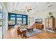 Sunlit living room with tray ceilings, wood floors, and large windows showcasing a serene view at 3228 Stonegate Falls Dr, Land O Lakes, FL 34638
