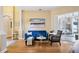 Cozy living room with hardwood floors, a blue velvet sofa, bright lighting, and sliding door to patio at 3228 Stonegate Falls Dr, Land O Lakes, FL 34638