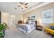 Relaxing primary bedroom suite boasting a tray ceiling, a ceiling fan, an ensuite bath, and neutral tones at 3228 Stonegate Falls Dr, Land O Lakes, FL 34638