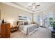 A spacious and serene primary bedroom features tray ceiling, large windows, and an ensuite bathroom at 3228 Stonegate Falls Dr, Land O Lakes, FL 34638