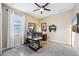 Office with a ceiling fan, a window with blinds, neutral walls, and multiple computer screens on an adjustable desk at 3228 Stonegate Falls Dr, Land O Lakes, FL 34638