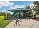 Community playground with shaded play area, benches, and a bike rack at 3228 Stonegate Falls Dr, Land O Lakes, FL 34638