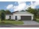 Charming single-story home with a gray driveway, well-maintained lawn, and a two-car garage at 36953 Sagemoor Dr, Zephyrhills, FL 33541