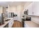Bright kitchen featuring stainless steel appliances, white cabinets, and an eat-in counter at 36953 Sagemoor Dr, Zephyrhills, FL 33541