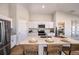 Bright kitchen featuring an island, white cabinets, stainless steel appliances, and seating for four at 36953 Sagemoor Dr, Zephyrhills, FL 33541