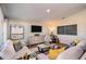 Open living room featuring comfortable seating, stylish decor, a large screen TV, and a well-lit and airy atmosphere at 36995 Sagemoor Dr, Zephyrhills, FL 33541