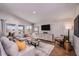 Bright living room featuring comfortable sofas, stylish decor, a large screen TV, and a well-lit and airy atmosphere at 36995 Sagemoor Dr, Zephyrhills, FL 33541