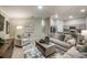 Open-concept living room featuring plush seating, neutral decor, and a view into the modern kitchen with stainless steel appliances at 36995 Sagemoor Dr, Zephyrhills, FL 33541