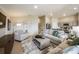 Open-concept living room with neutral tones, modern decor, and seamless flow into the kitchen area at 36995 Sagemoor Dr, Zephyrhills, FL 33541
