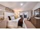 Bright main bedroom featuring a large bed, neutral decor, and natural light from two windows at 36995 Sagemoor Dr, Zephyrhills, FL 33541